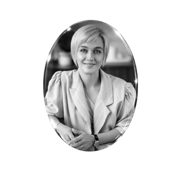 Foto oval en cristal sobre fondo blanco, retrato en blanco y negro de una mujer sonriente de pelo corto y chaqueta clara