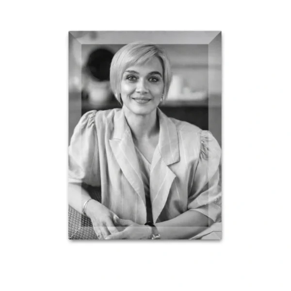 Black and white rectangular memorial photo on crystal on a white background: smiling woman with short hair in a light jacket