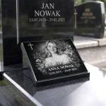 Tabliczki z napisem na cmentarz ze zdjęciem na szkle ustawione na poduszce granitowej
