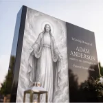 low angle view of tall modern black granite headstone with glass panel of Jesus against the sky