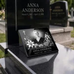 Glass photo plaque for grave with portrait, name and dates on black granite headstone