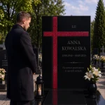 szklany krzyż asymetryczny na nagrobek, kolorowy krzyż szklany na cmentarz na czarnym pomniku granitowym