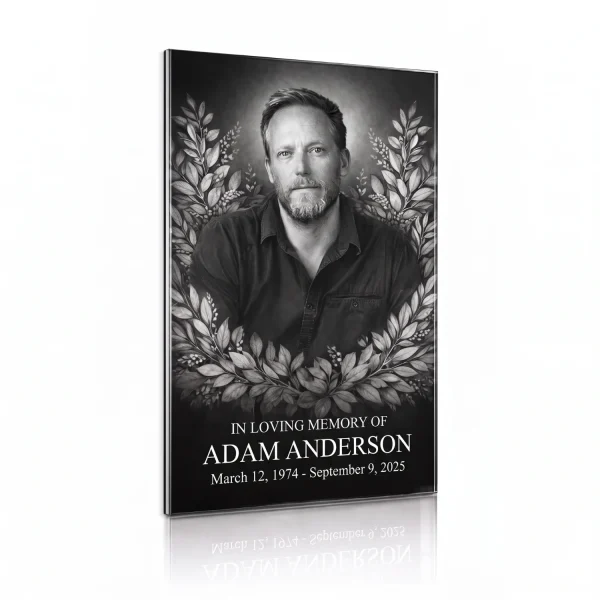 Black glass plaque with a black and white portrait of a bearded man in a laurel wreath