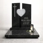 corazón de vidrio triturado montado en una lápida de granito negro