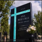 Cruz asimétrica de vidrio fusionado encastrada en una lápida de granito negro
