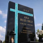 Cruz de vidrio fusionado turquesa en una tumba de granito
