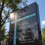 Cruz asimétrica de vidrio turquesa en una lápida de granito negro