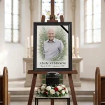 Large custom photo for headstone displayed on easel with floral wreath and text