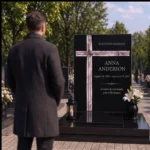 Asymmetric fused-glass cross on a black granite headstone