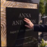 Ivory and gold asymmetric glass cross on a black granite headstone