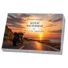 Memorial plaque in glass with a motorcycle on a coastal road at sunset, on a granite base