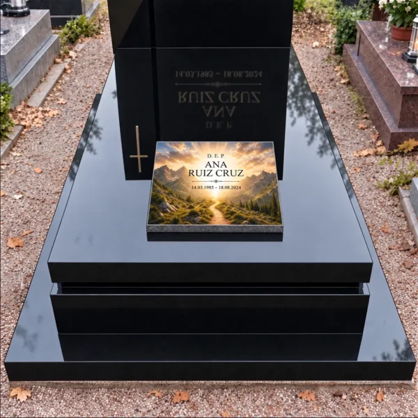 Placa conmemorativa con motivo de sendero de montaña en la losa de una lápida negra, vista frontal