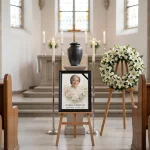 portret pamiątkowy zmarłego w ramie na sztaludze pogrzebowej