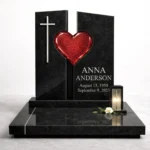 red fused glass heart on a black granite headstone