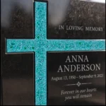 Turquoise asymmetric glass cross on a black granite headstone