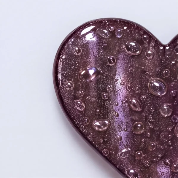 purple transparent glass heart with bubbles for a headstone, close-up of the edge