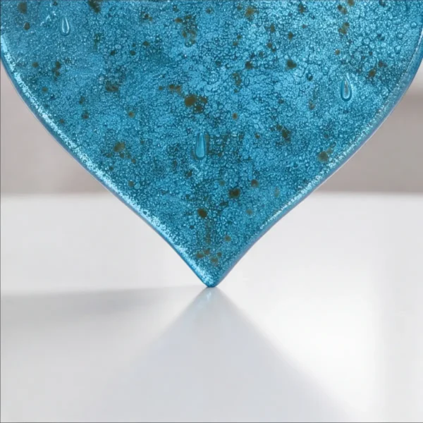 speckled turquoise transparent glass heart for a headstone, close-up of the glass texture